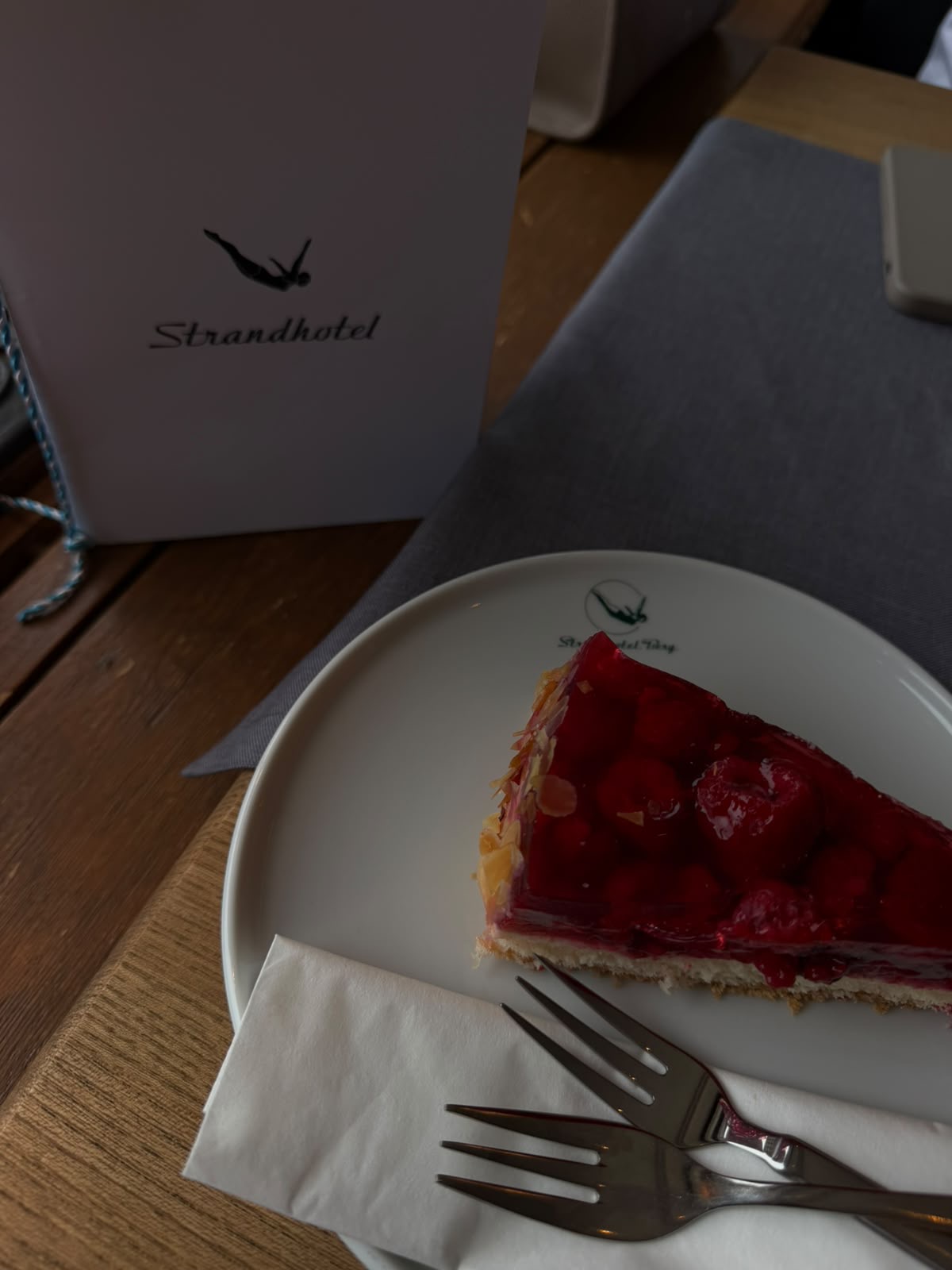 Ein Stück Erdbeerkuchen aufgeschnitten auf einem Teller angerichtet, auf einem Tisch in der alten Stube